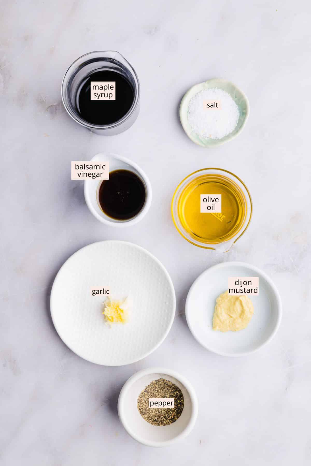 Maple balsamic dressing ingredients on a countertop with labels.