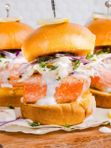A close up shot of a salmon slider with slaw and sauce.
