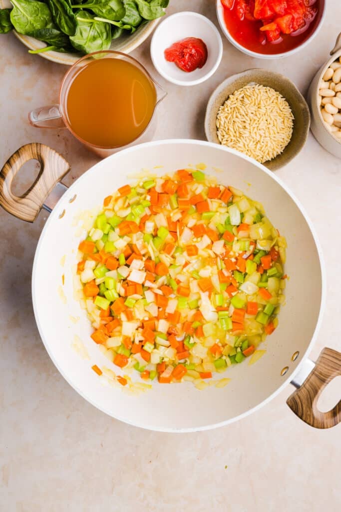 Veggies being sautéed in a large pot.