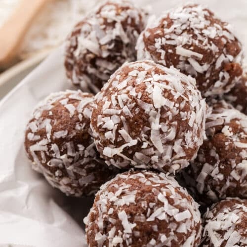 Coconut protein balls piled on a plate.