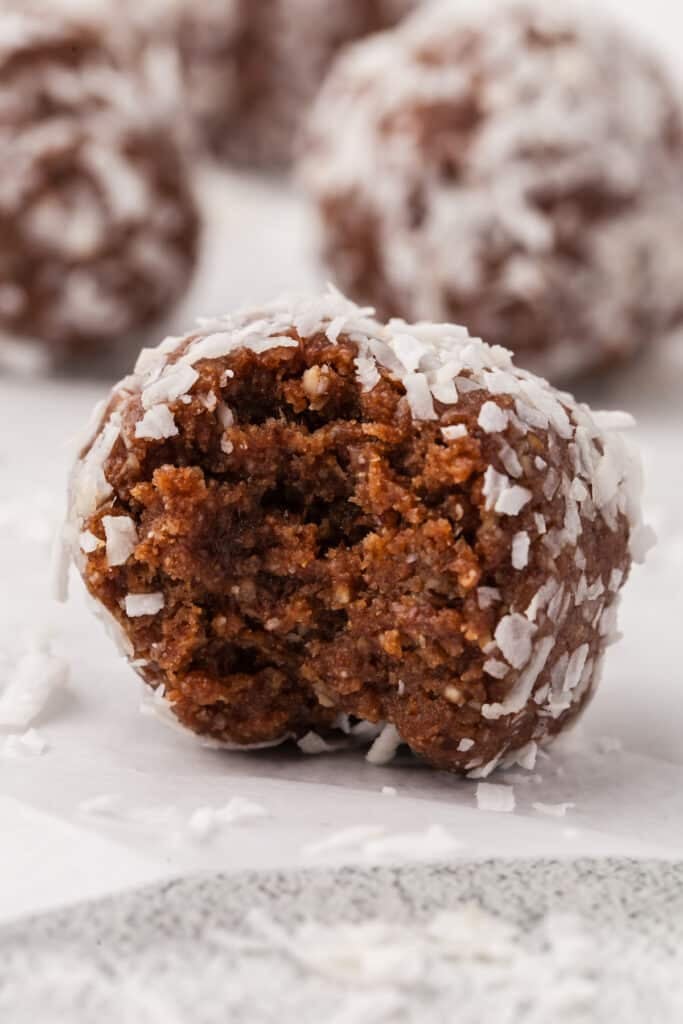 A close up bite shot of a coconut protein ball.