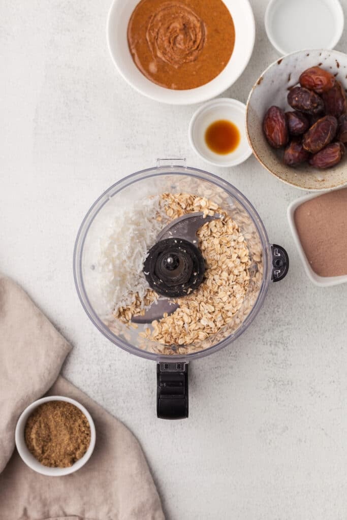 Shredded coconut and rolled oats in a food processor before being processed.
