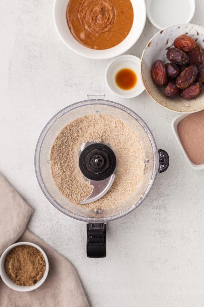 Shredded coconut and rolled oats in a food processor after being blended.