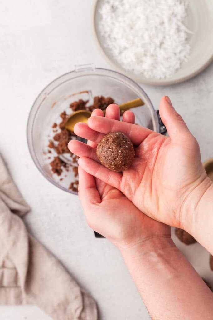 Coconut protein balls being rolled.