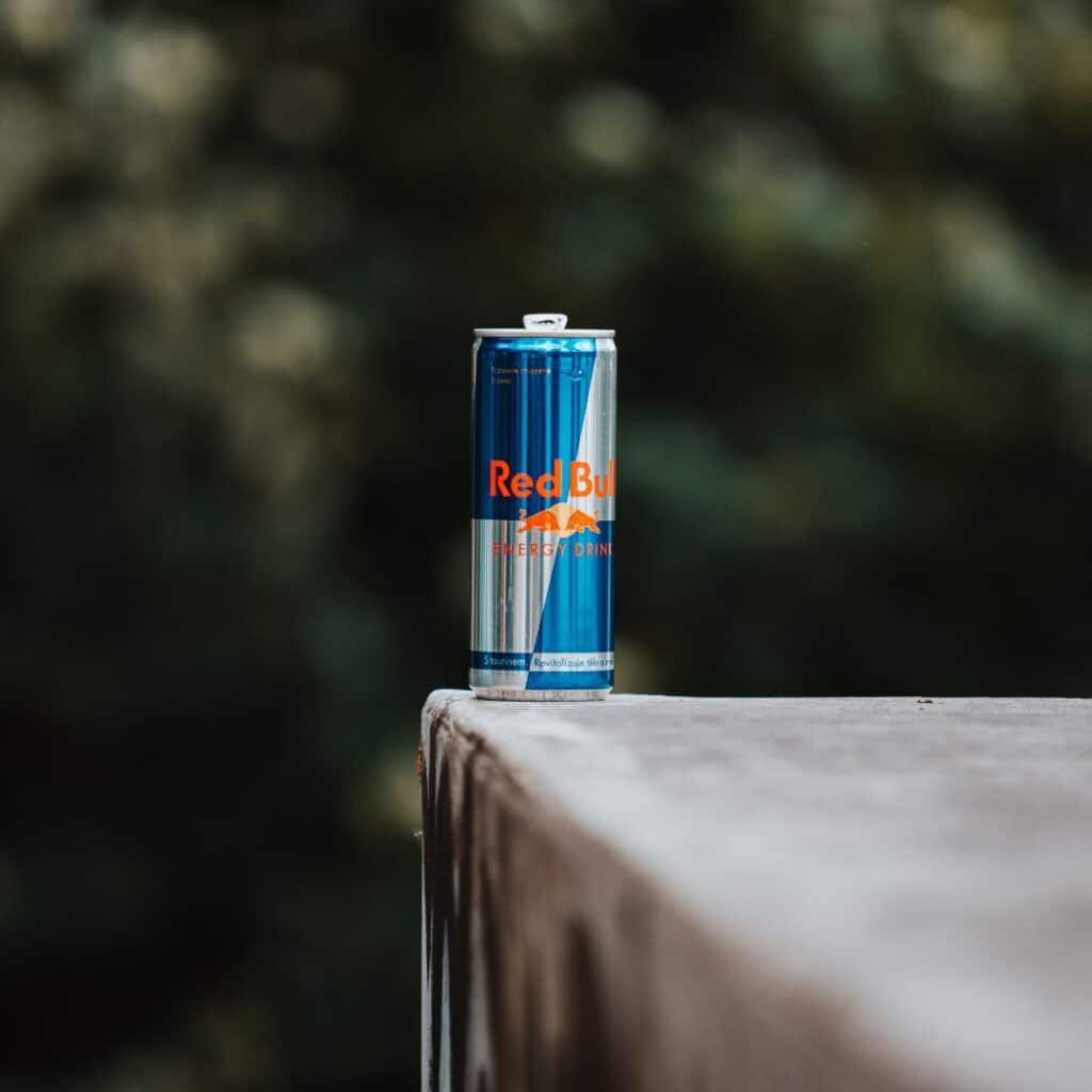 A can of Red Bull on the edge of a ledge.