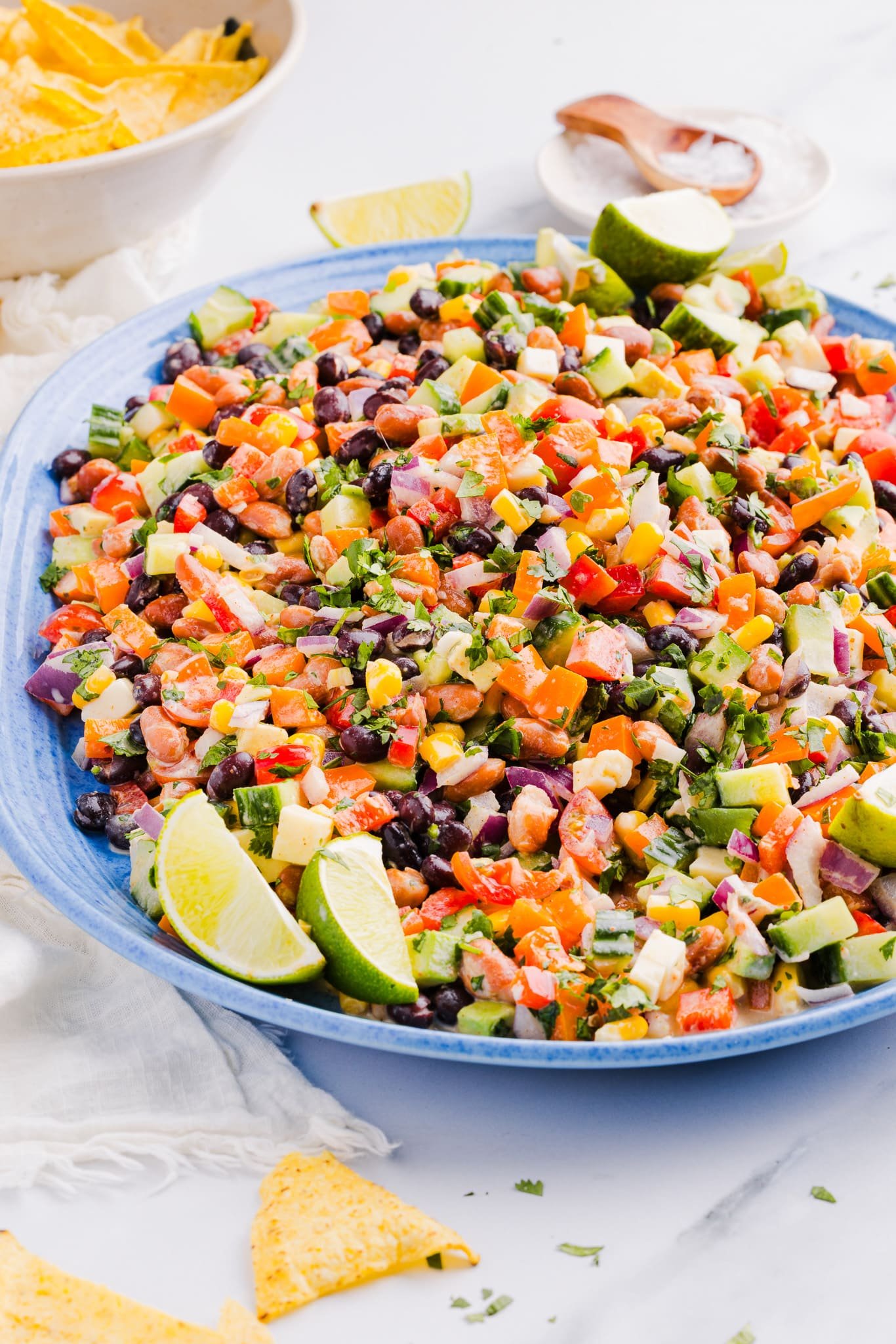 Creamy cowboy caviar on a large blue platter with tortilla chips.