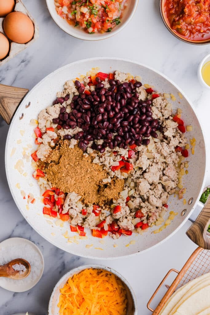 Ground turkey, peppers, taco seasoning and beans in a pan.