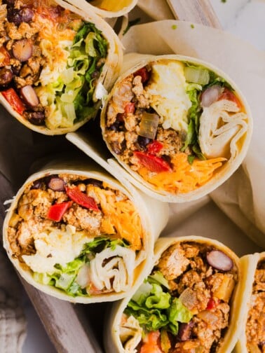 A close up shot of high protein breakfast burritos sliced in half.