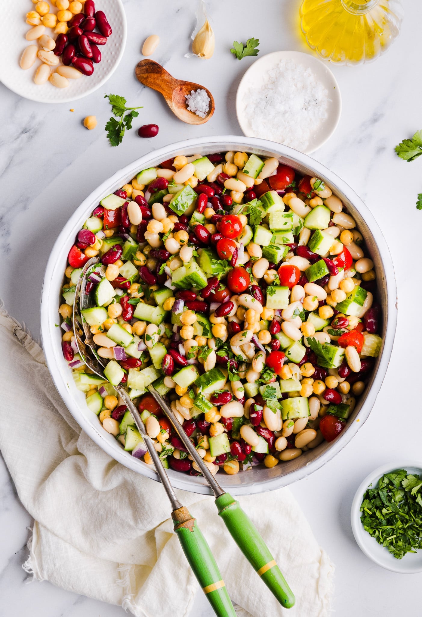 Italian bean salad in a large bowl with serving spoons.
