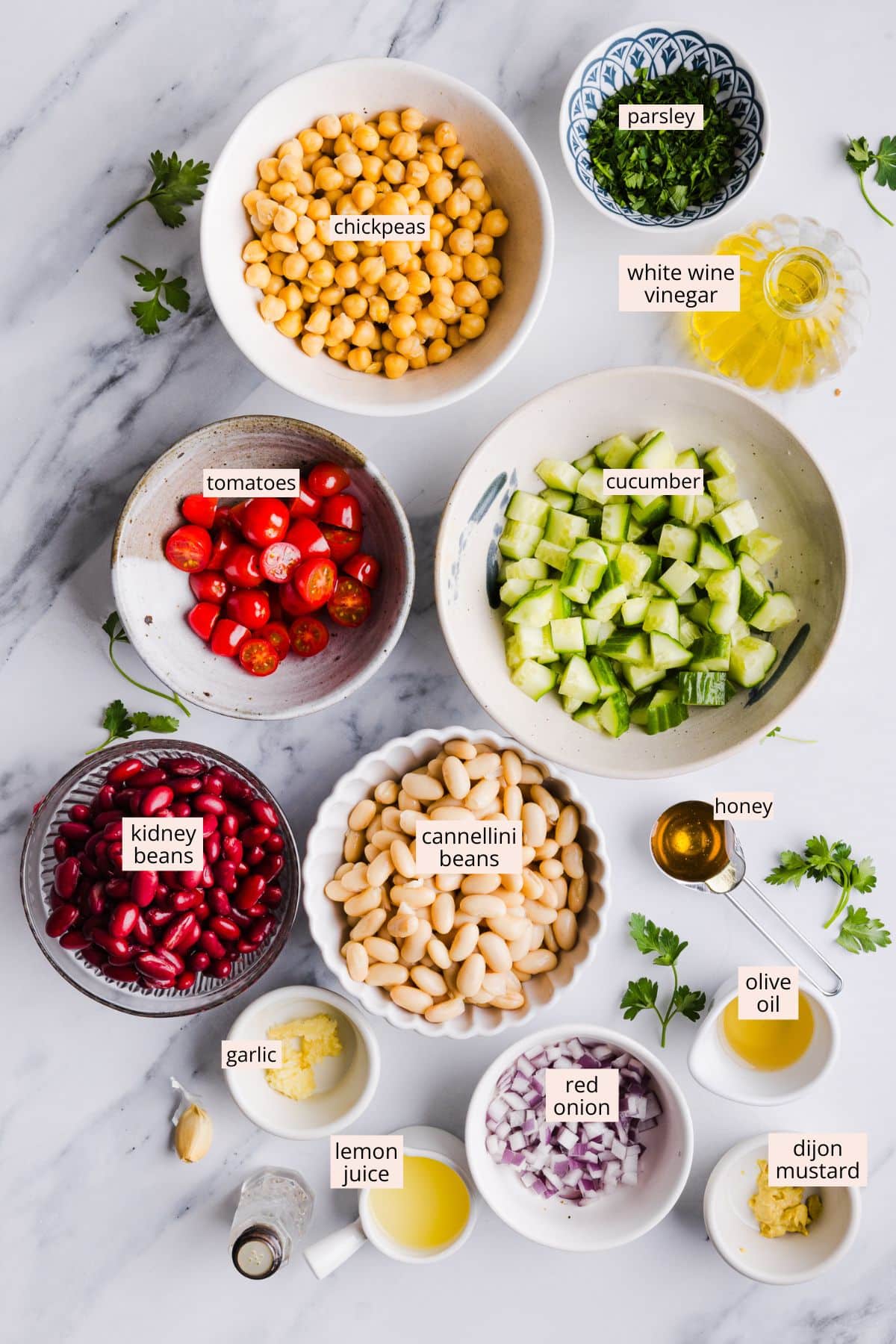 Ingredients for Italian bean salad on a countertop with labels.