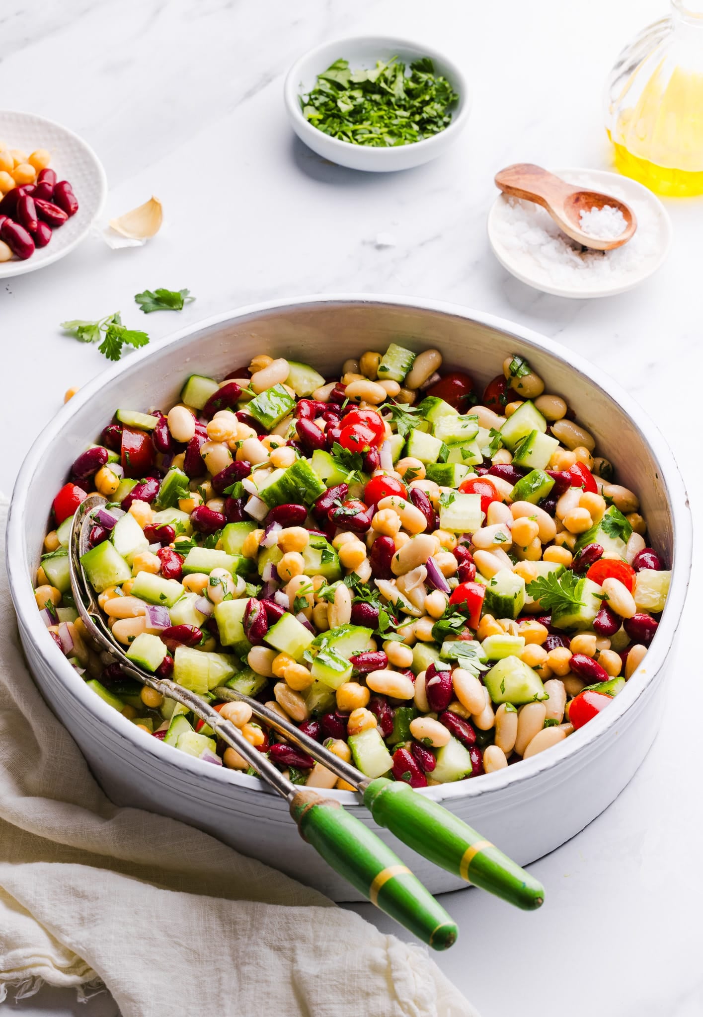 Italian bean salad in a large bowl with serving spoons.