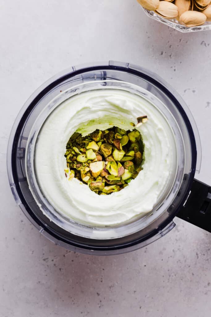 Pistachios being mixed into Ninja Creami pistachio ice cream.