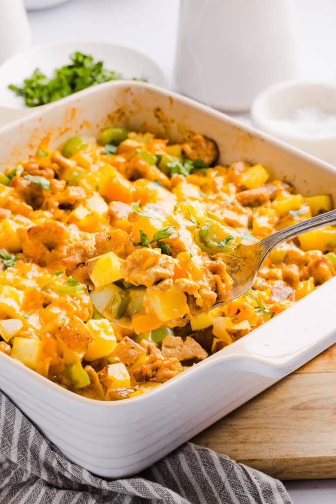 A scoop of no egg breakfast casserole in a baking dish.