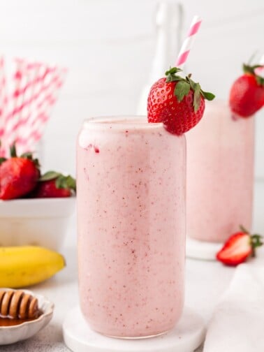 A strawberry banana smoothie garnished with a strawberry.