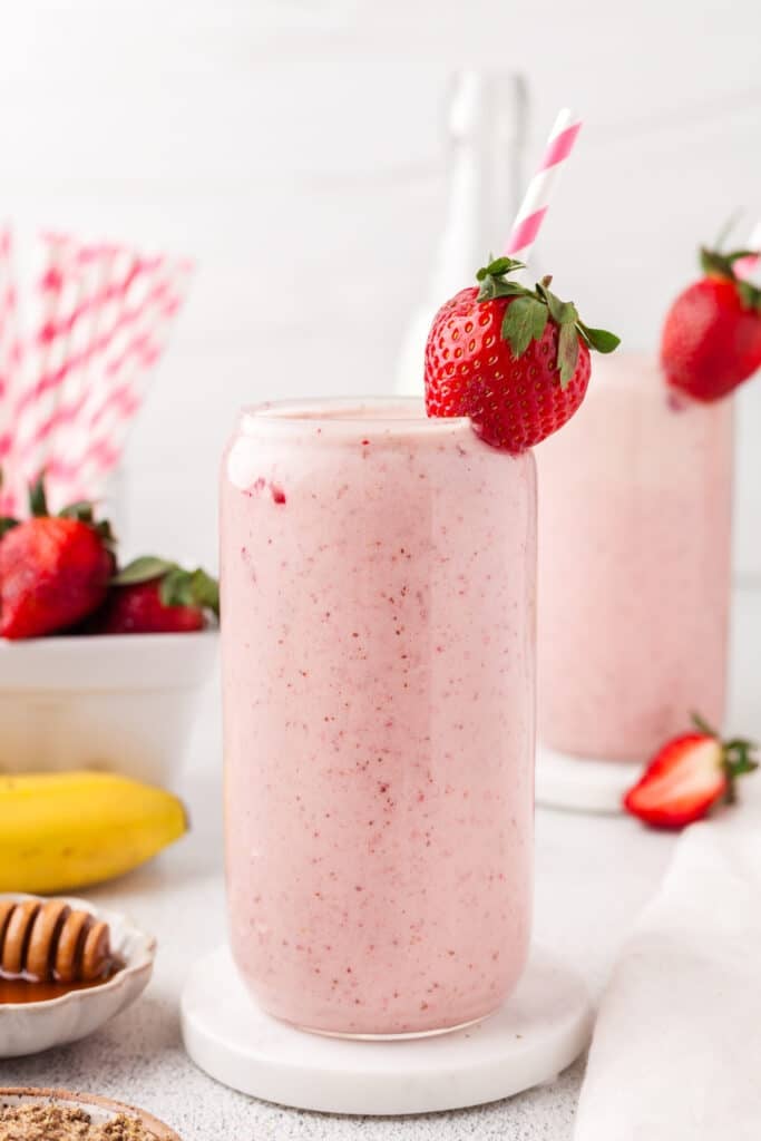 A strawberry banana smoothie garnished with a strawberry.