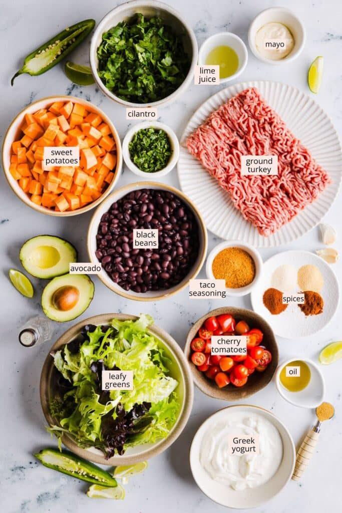Ingredients for sweet potato taco bowls on a countertop with labels.
