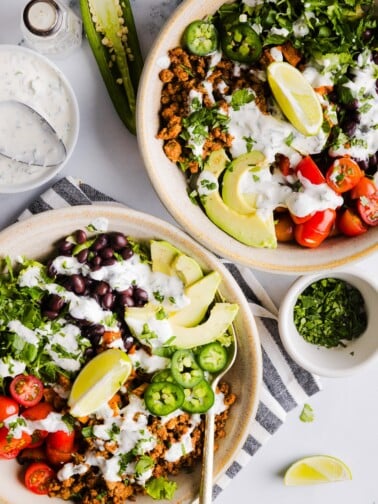 Sweet potato taco bowls assembled with garlic yogurt dressing on top.