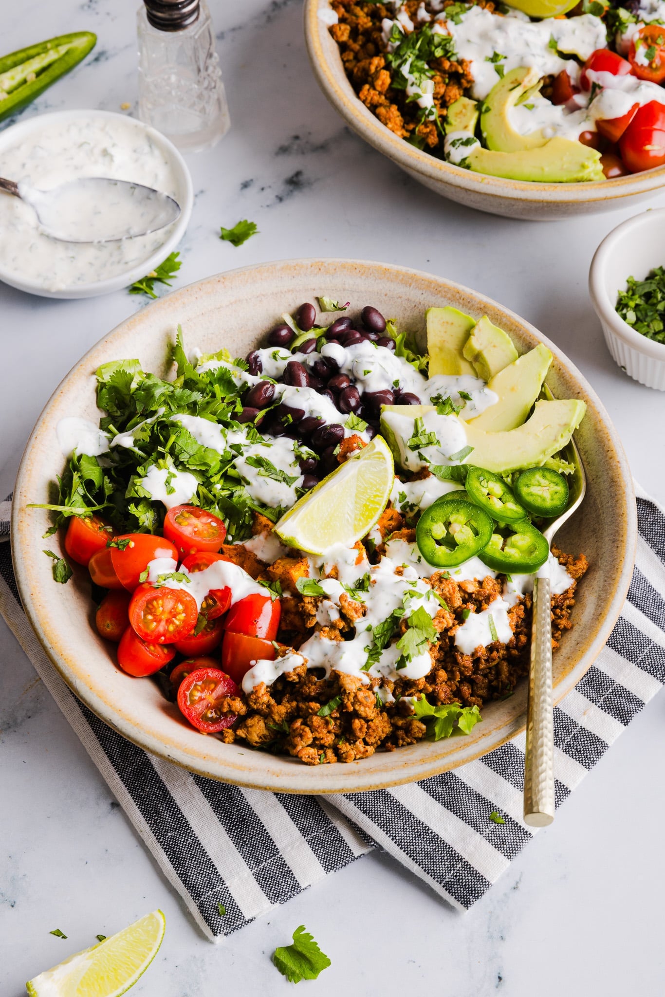 A sweet potato taco bowl assembled with garlic yogurt dressing on top.
