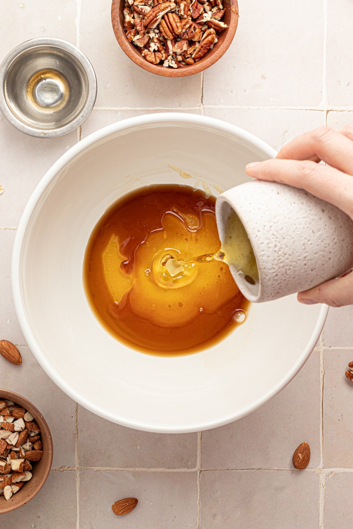 Oil being poured into a bowl with honey and vanilla