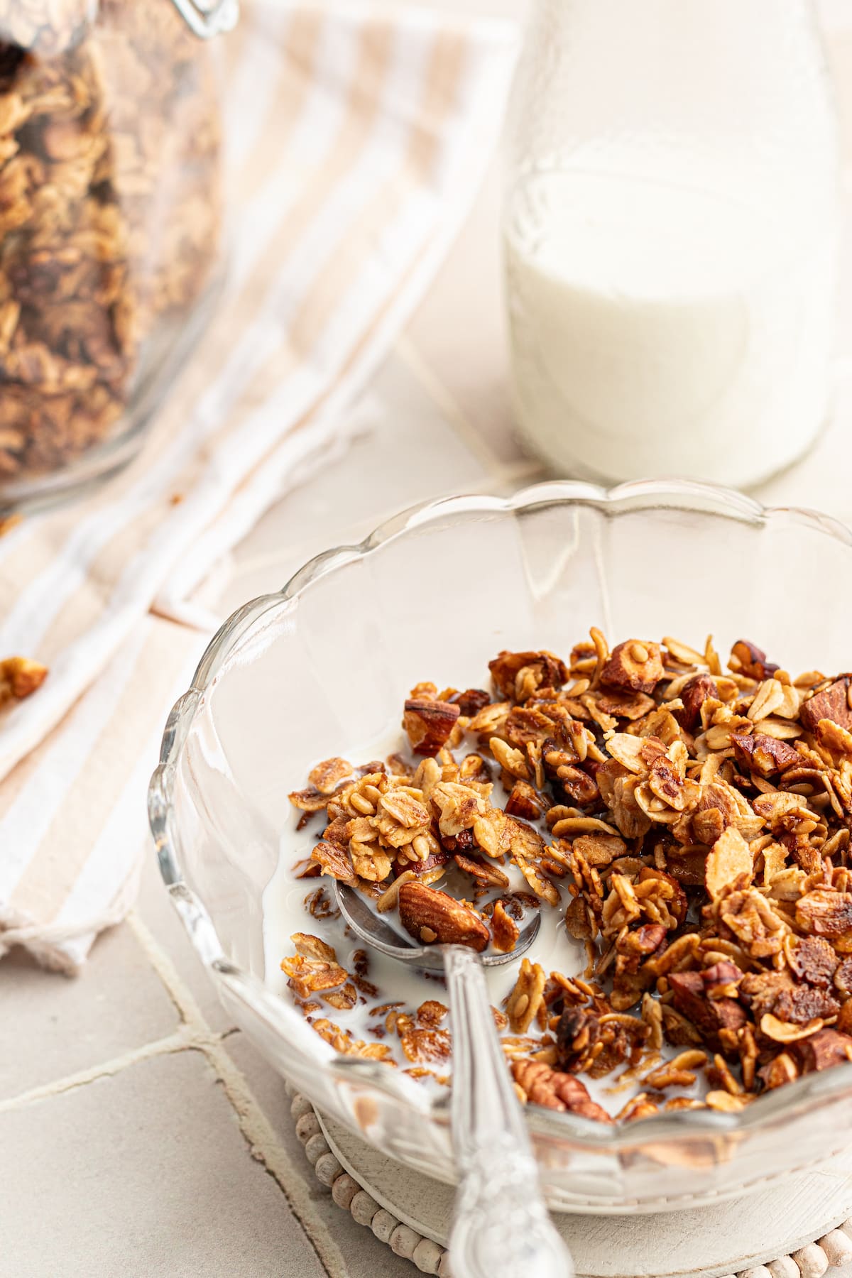 A bowl of vanilla nut granola with milk and a spoon.