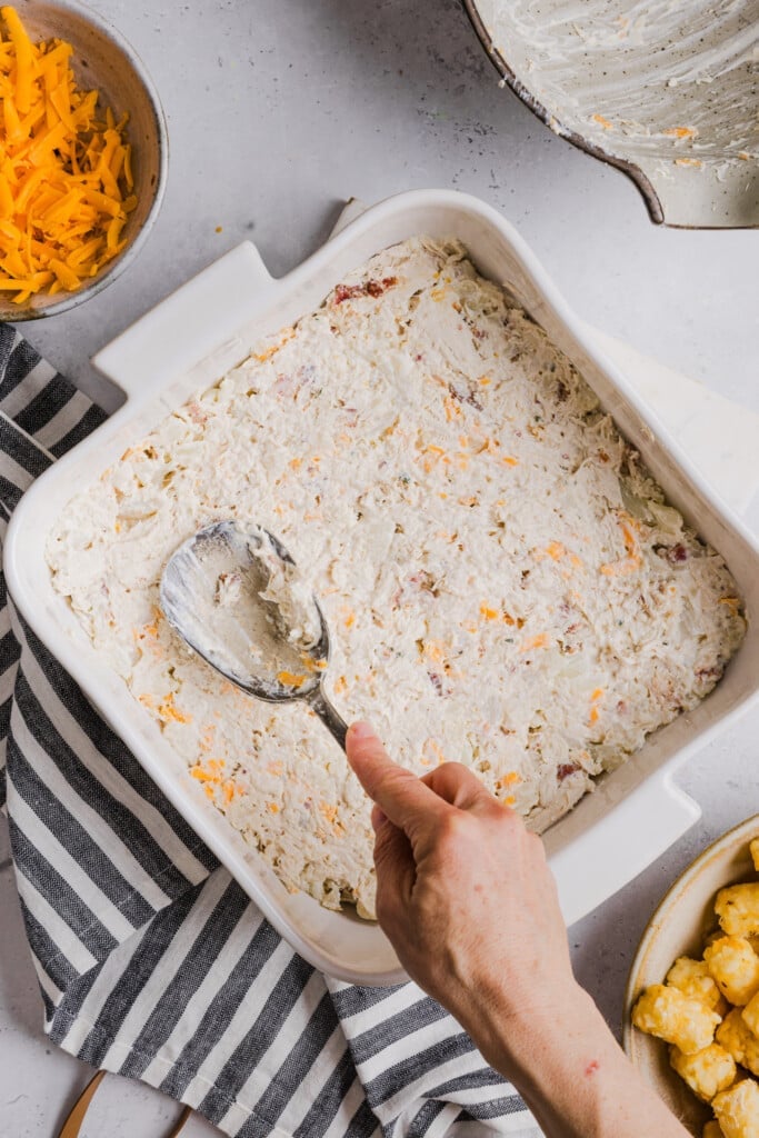 Chicken bacon ranch tear tot casserole filing added to a baking dish.