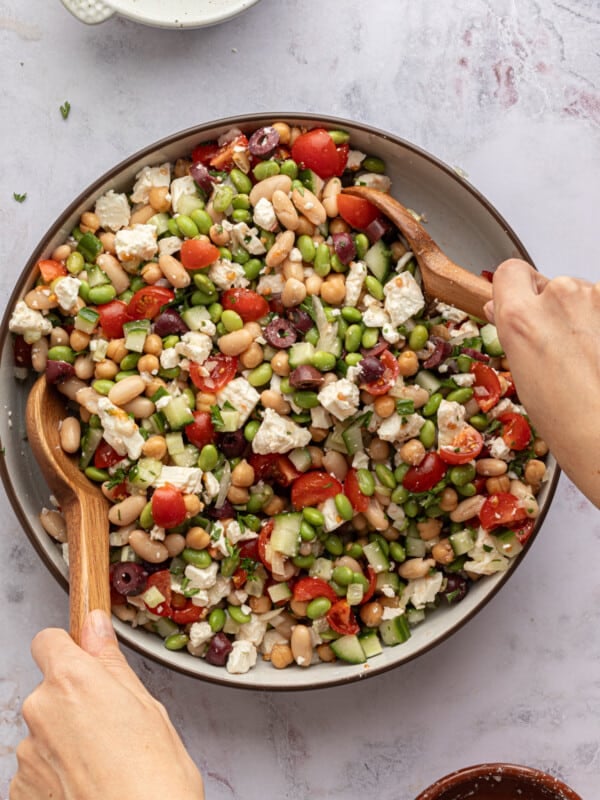 High protein bean salad being mixed in a large bowl.