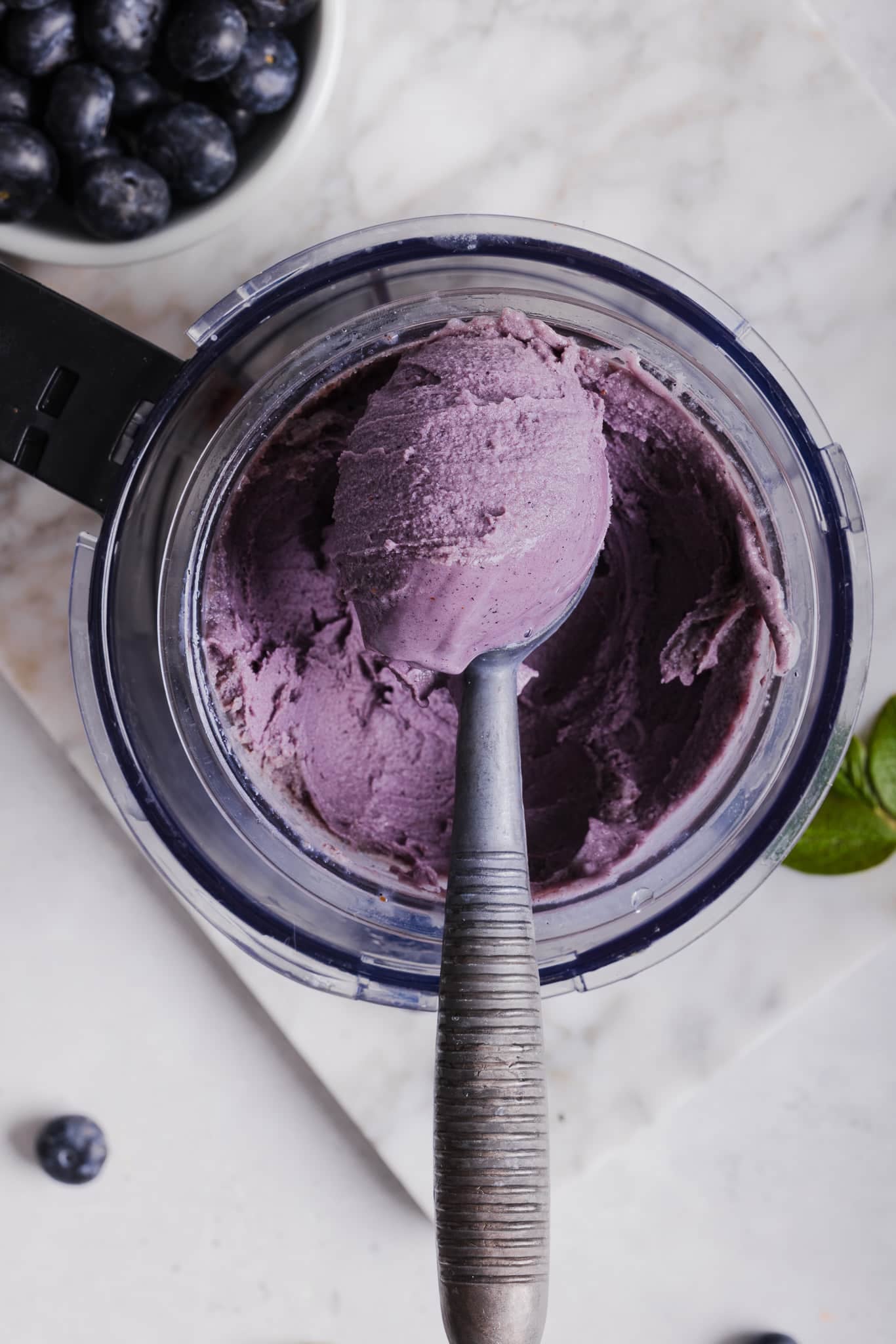 Ninja creami blueberry ice cream being scooped out of the container.
