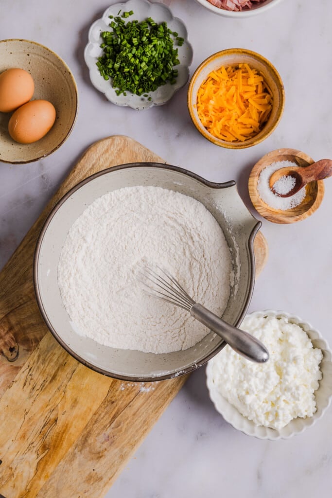 Dry ingredients for protein biscuits in a bowl with a whisk.