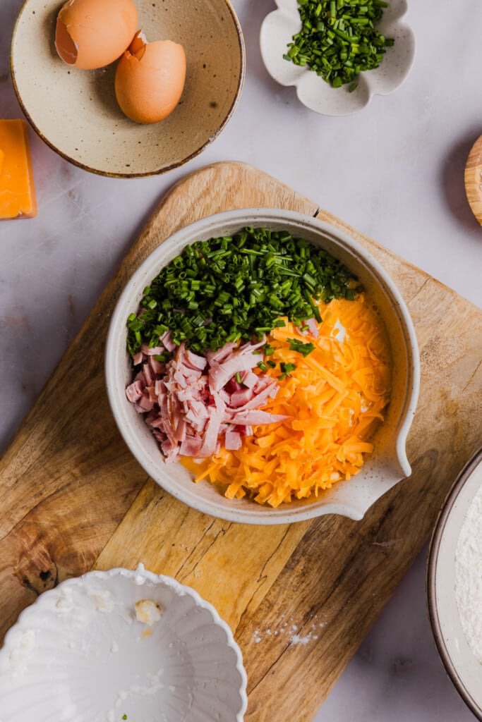 Cottage cheese, chives, ham and cheese in a bowl about to be mixed.