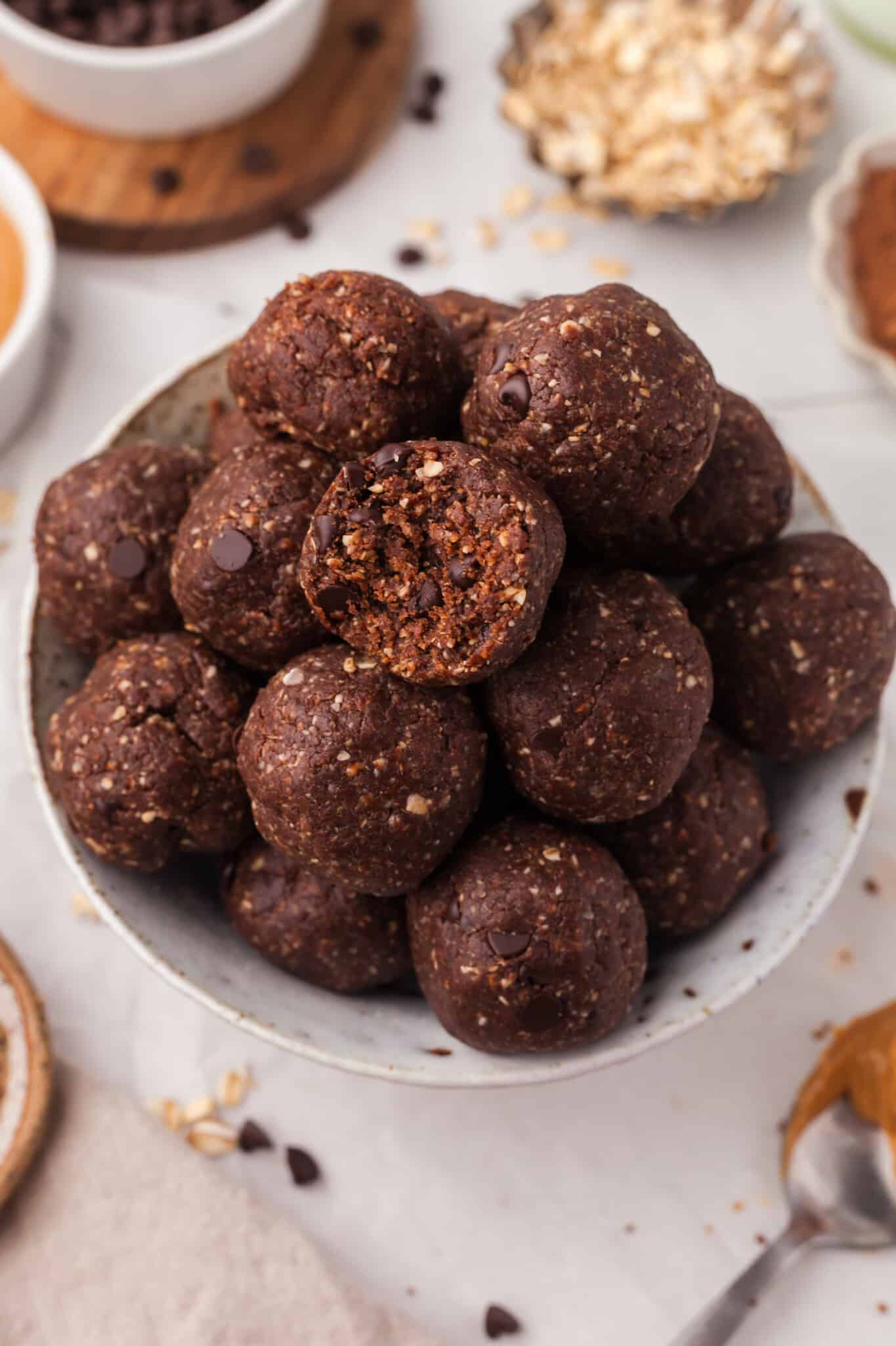 A pile of brownie protein bites on a plate with a bite taken out.