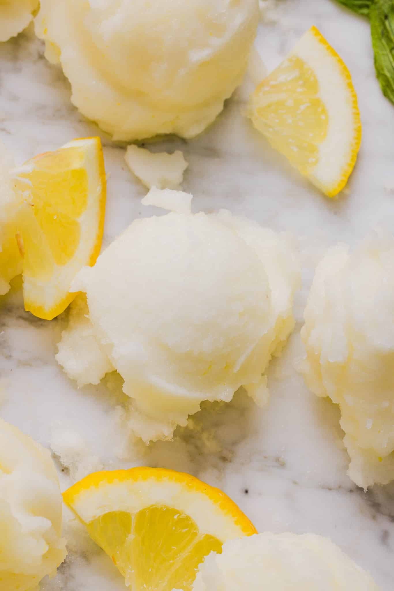 Scoops of lemon sorbet with lemon slices. 