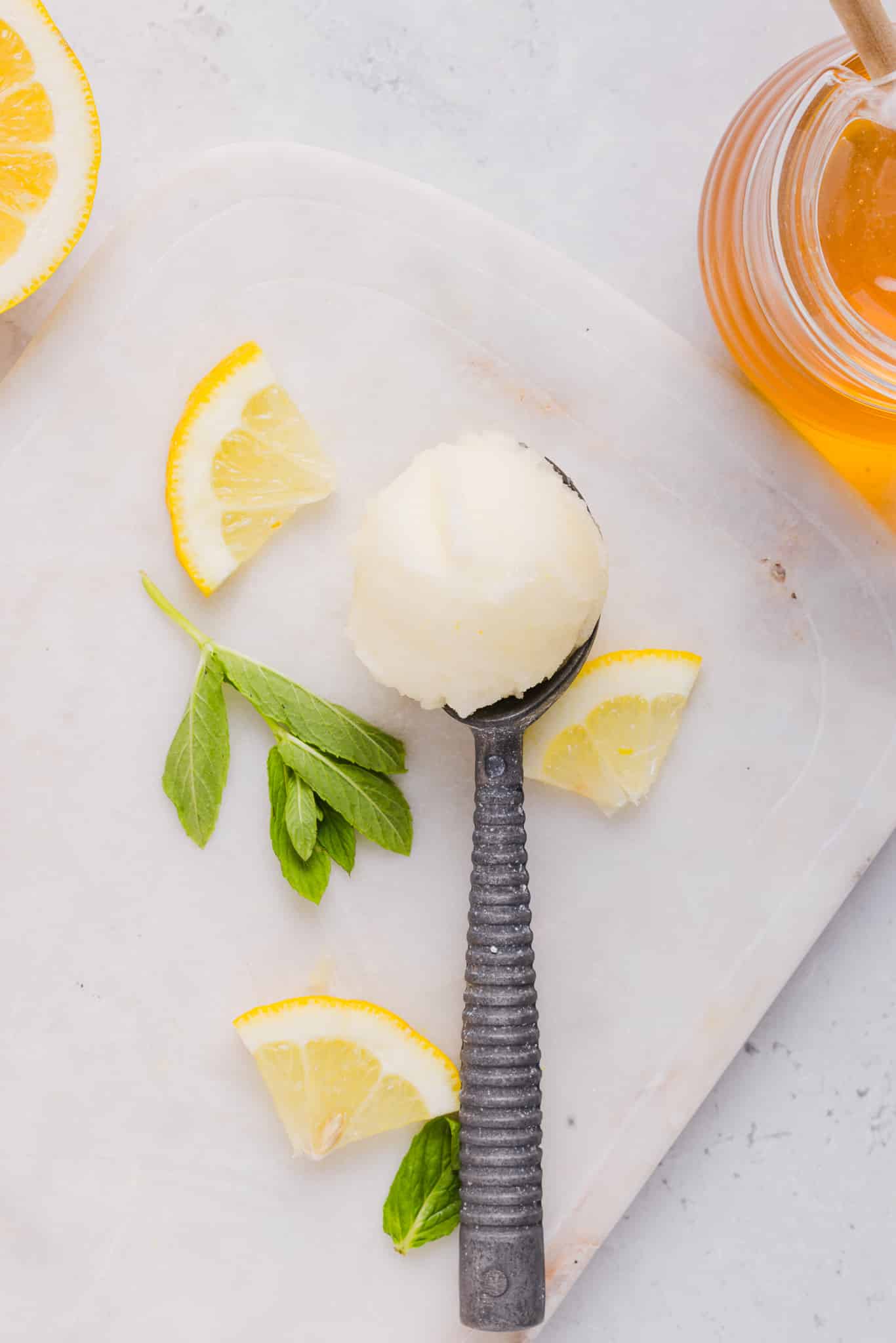 A spoon with a scoop of lemon sorbet.