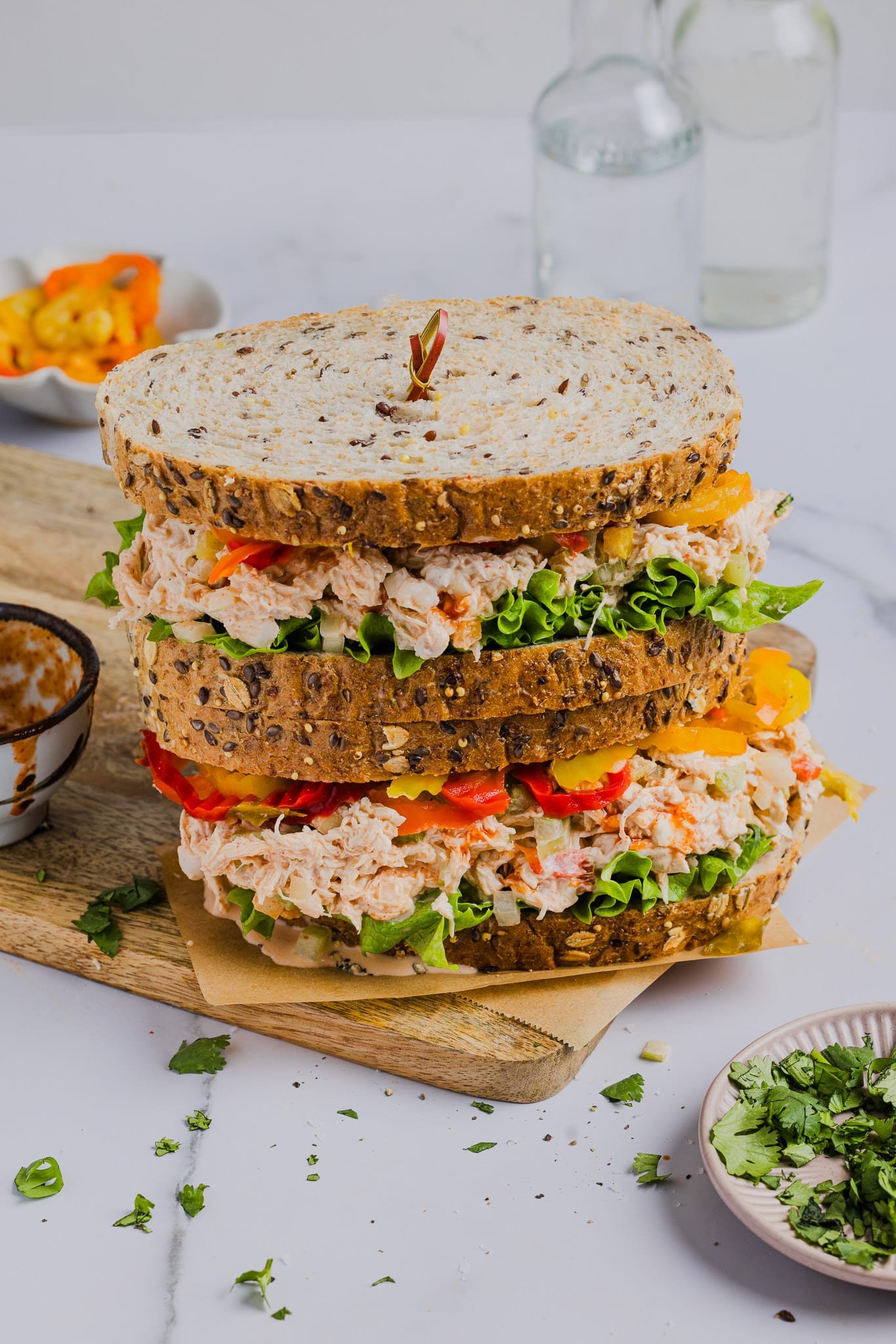 Two spicy chicken salad sandwiches on top of each other.