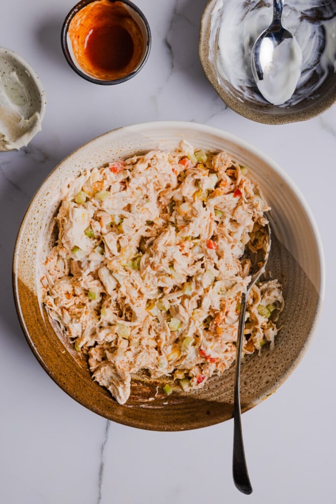 Spicy chicken salad mixed together in a bowl.