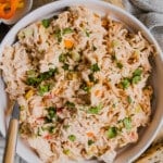 A serving spoon in a bowl of spicy chicken salad.