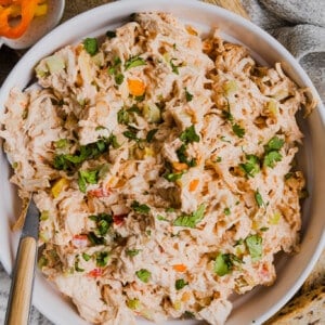 A serving spoon in a bowl of spicy chicken salad.