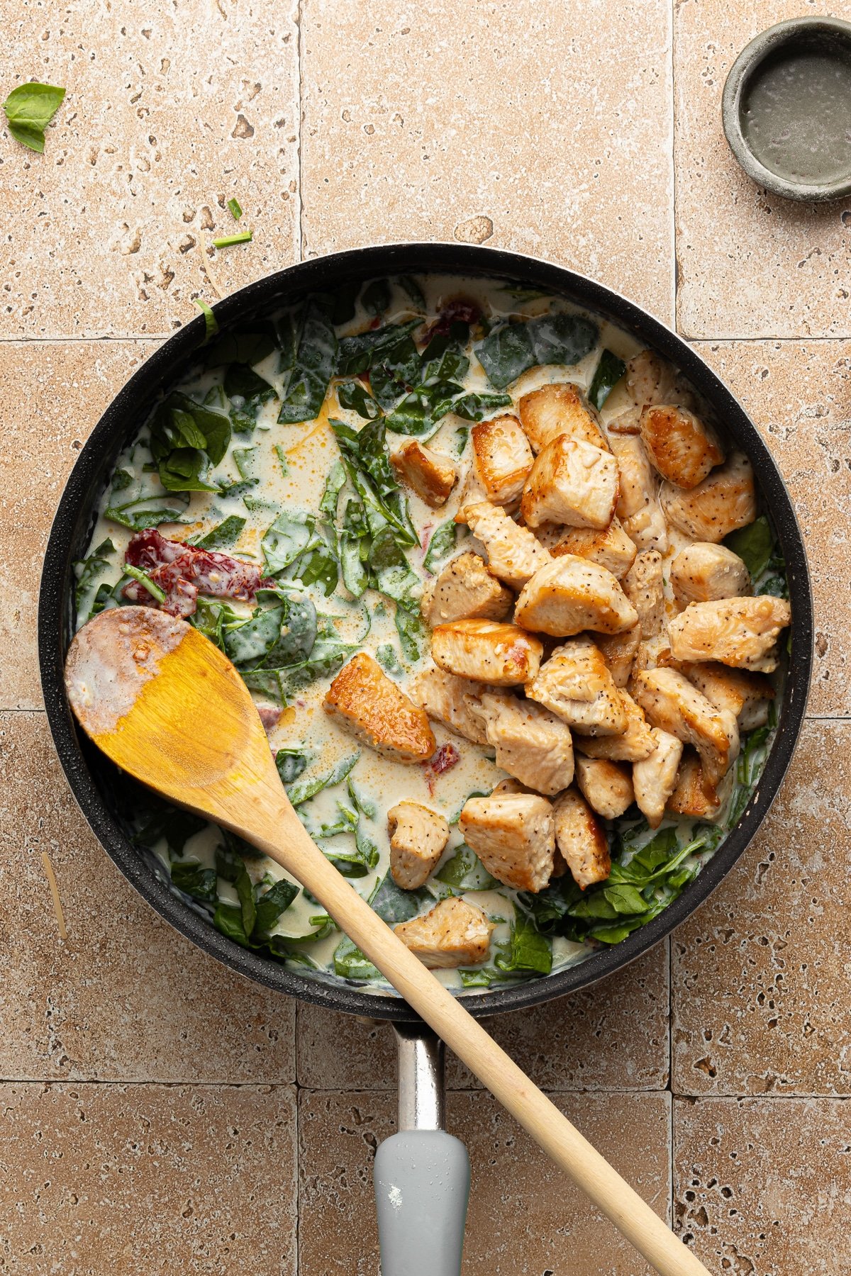 Marry me chicken pasta cooking in a pan with the chicken added.