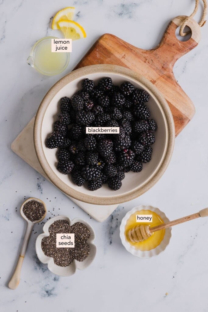 Ingredients for blackberry chia jam on a countertop with labels.