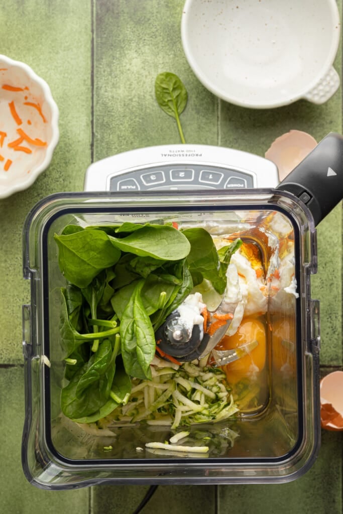 Veggies in a blender with eggs and other ingredients for chocolate veggie muffins.