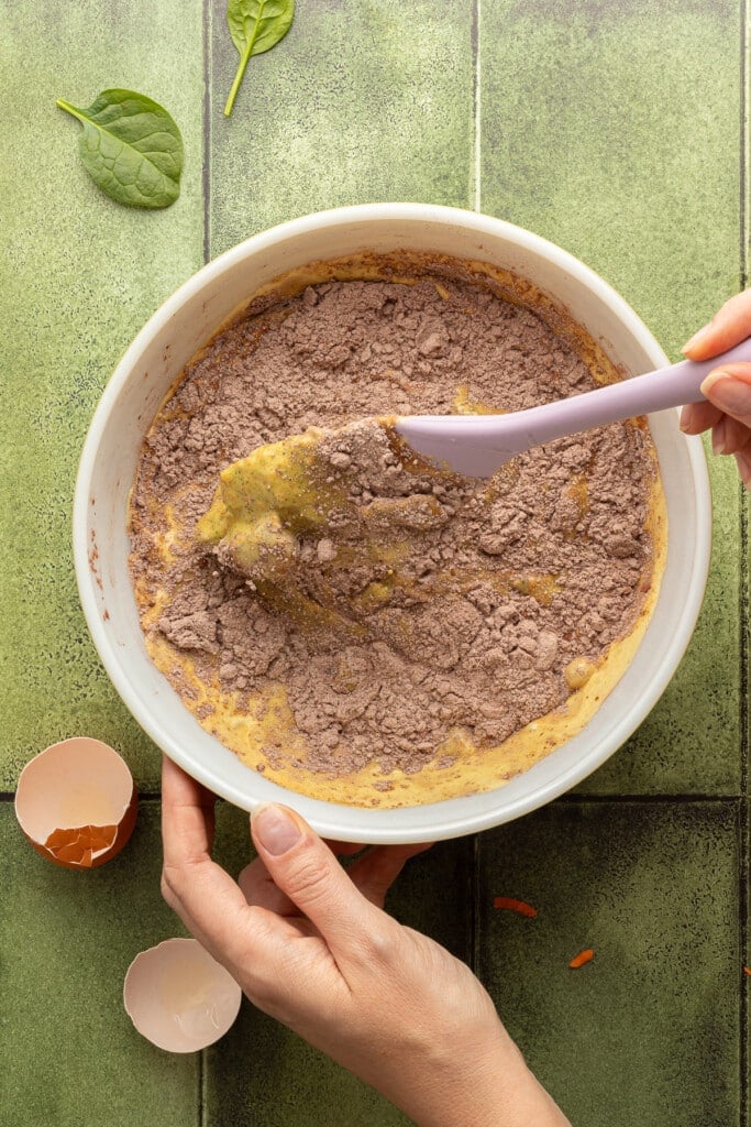 Dry ingredients and wet ingredients being mixed in a bowl.