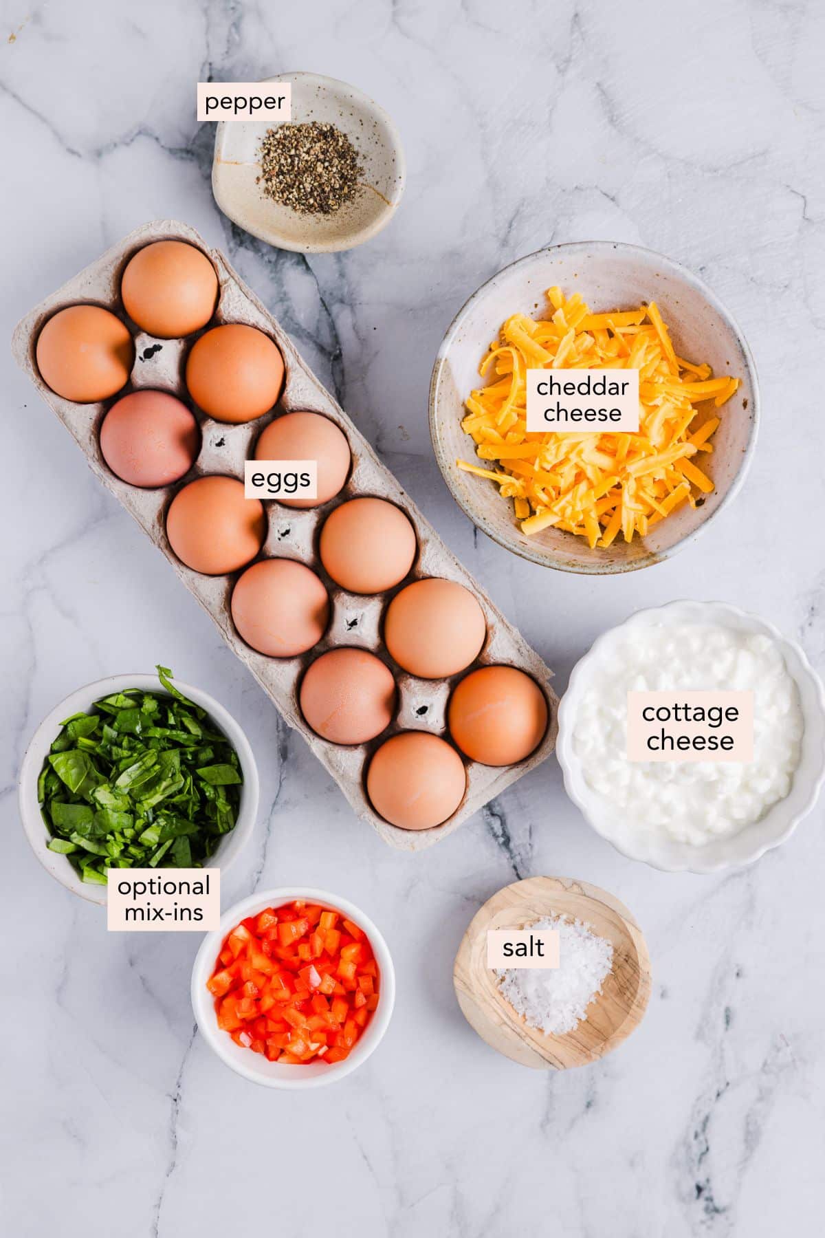 Ingredients for cottage cheese egg bites on a countertop with labels.