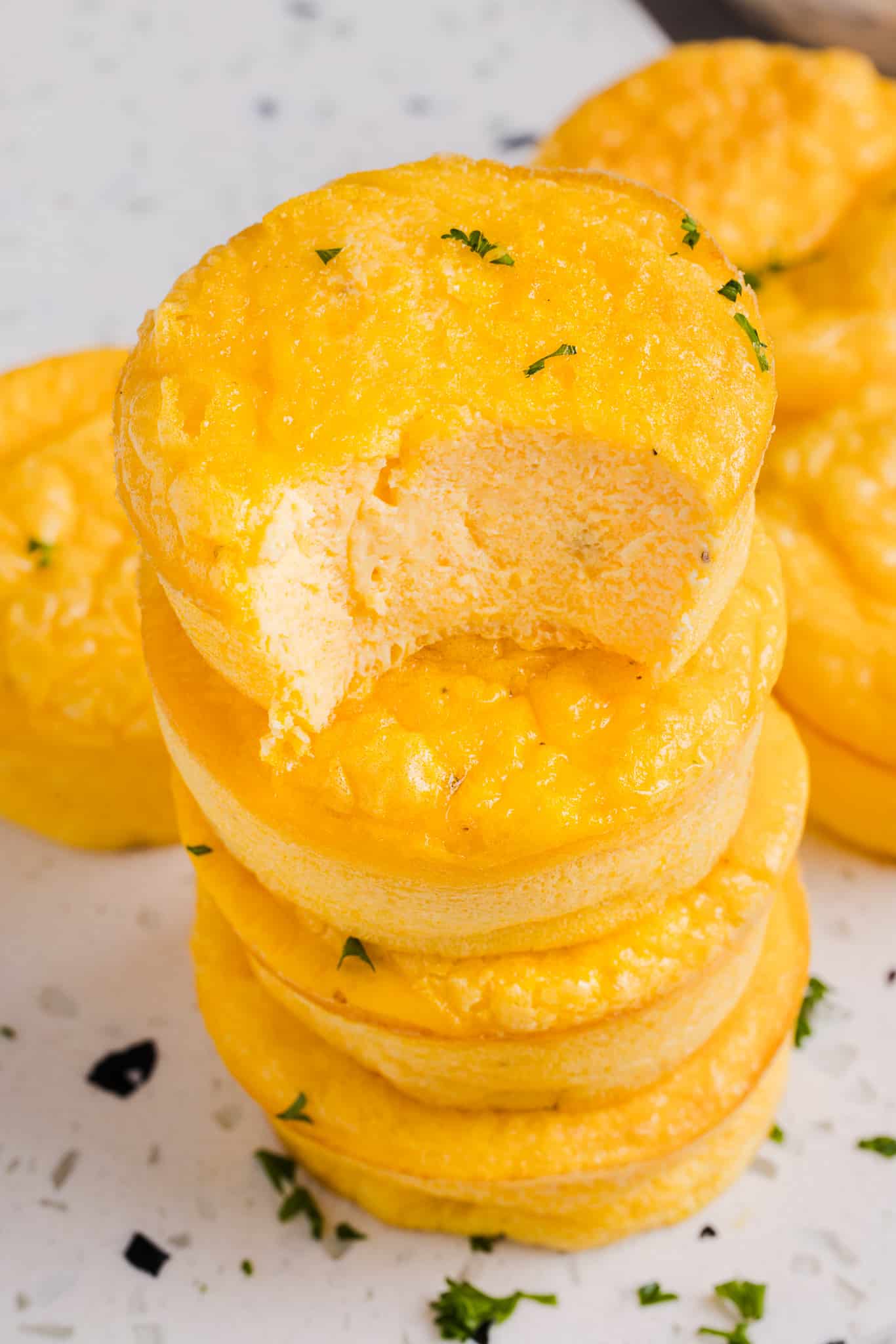 A stack of cottage cheese egg bites with a bite taken out of one.