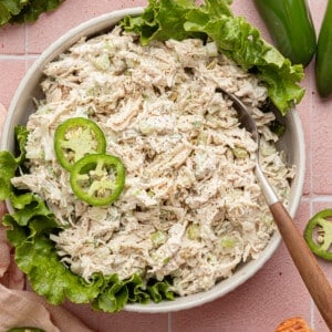 Jalapeño chicken salad in a shalow bowl with lettuce and garnished with jalapeños.