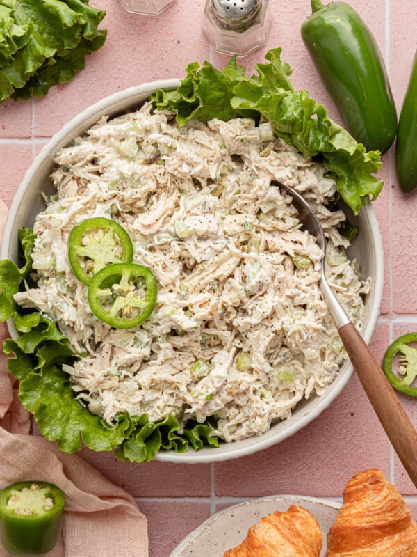 Jalapeño chicken salad in a shalow bowl with lettuce and garnished with jalapeños.