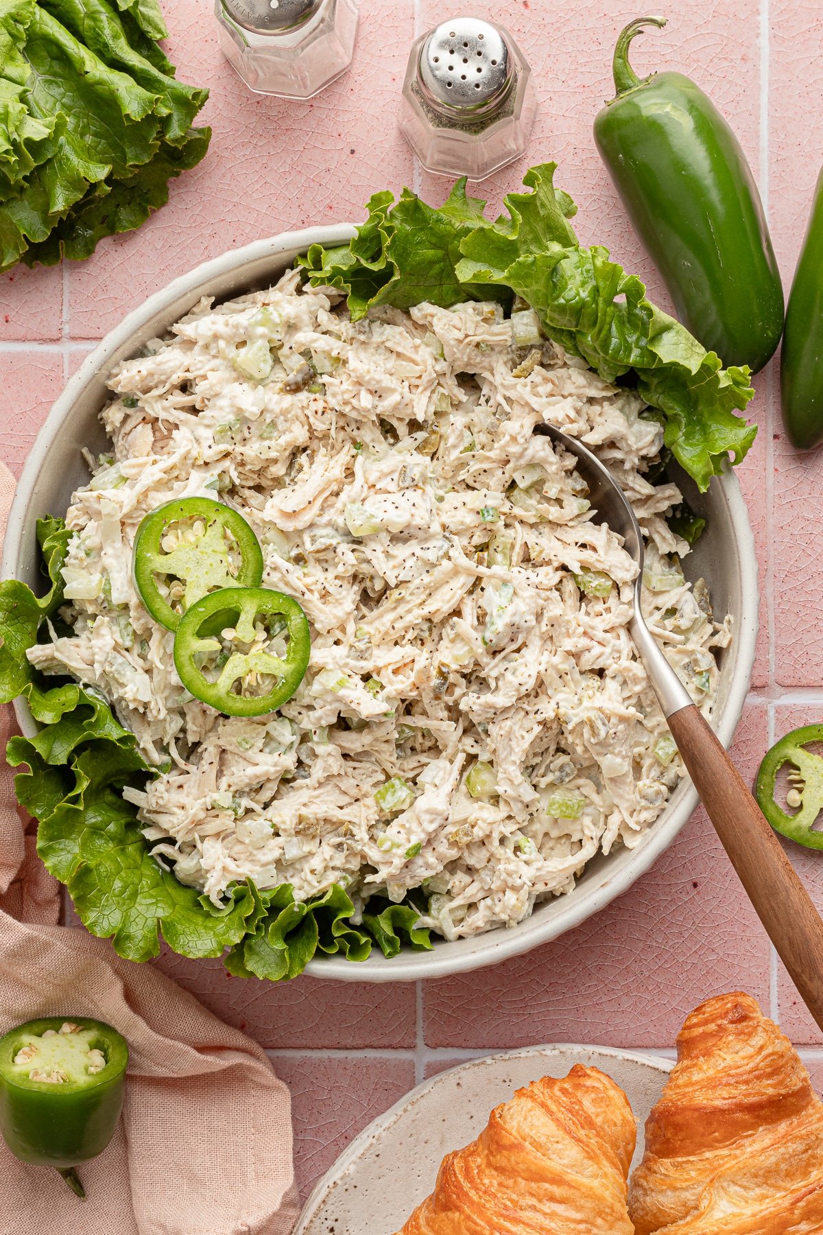 Jalapeño chicken salad in a shalow bowl with lettuce and garnished with jalapeños.