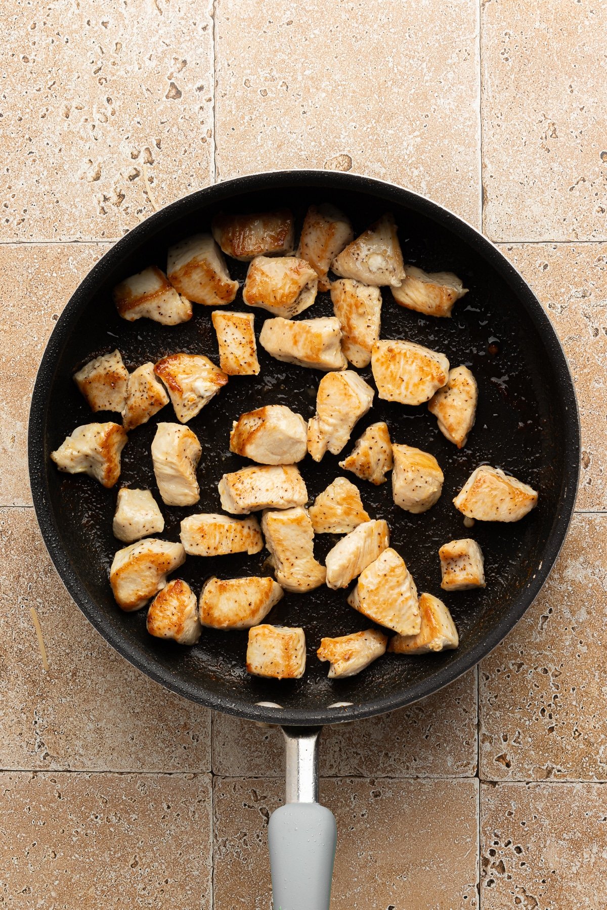 Cooked chicken pieces in a large skillet.