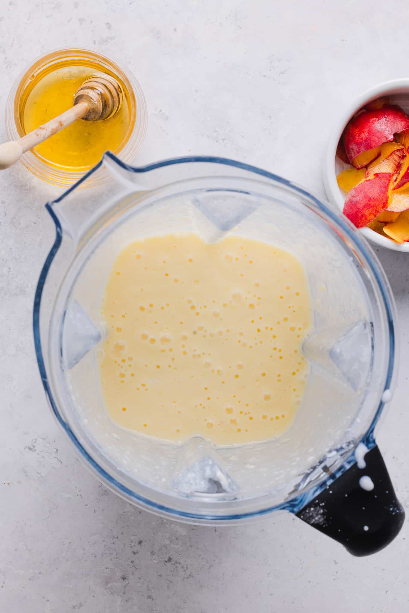 Blended ingredients for Ninja Creami peach ice cream in a blender.