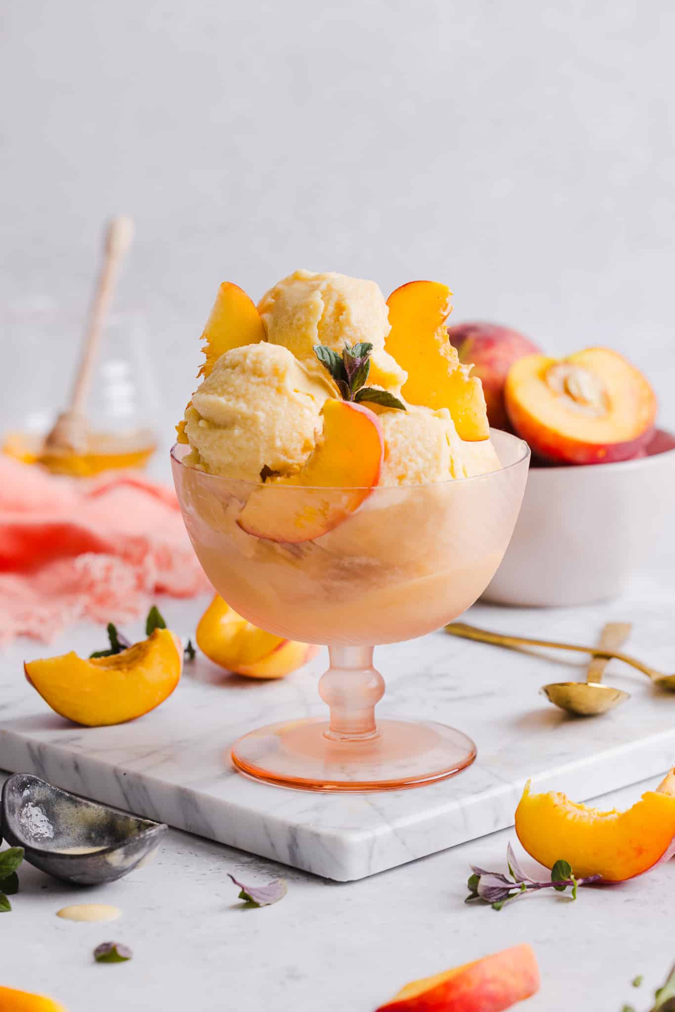 Peach ice cream served in a bowl with peach slices.