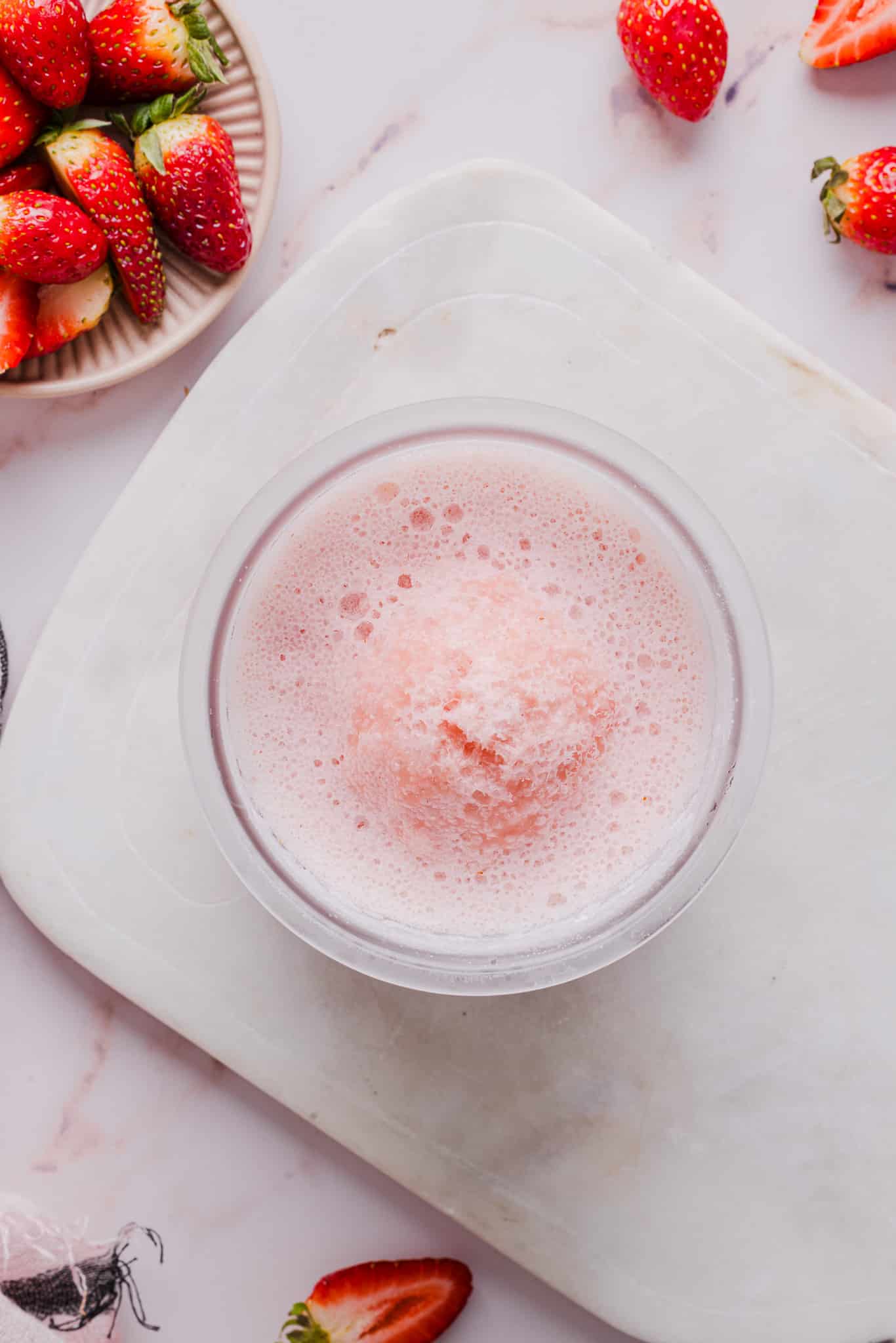 Ingredients for strawberry ice cream blended together and then frozen in a Ninja Creami pint container.