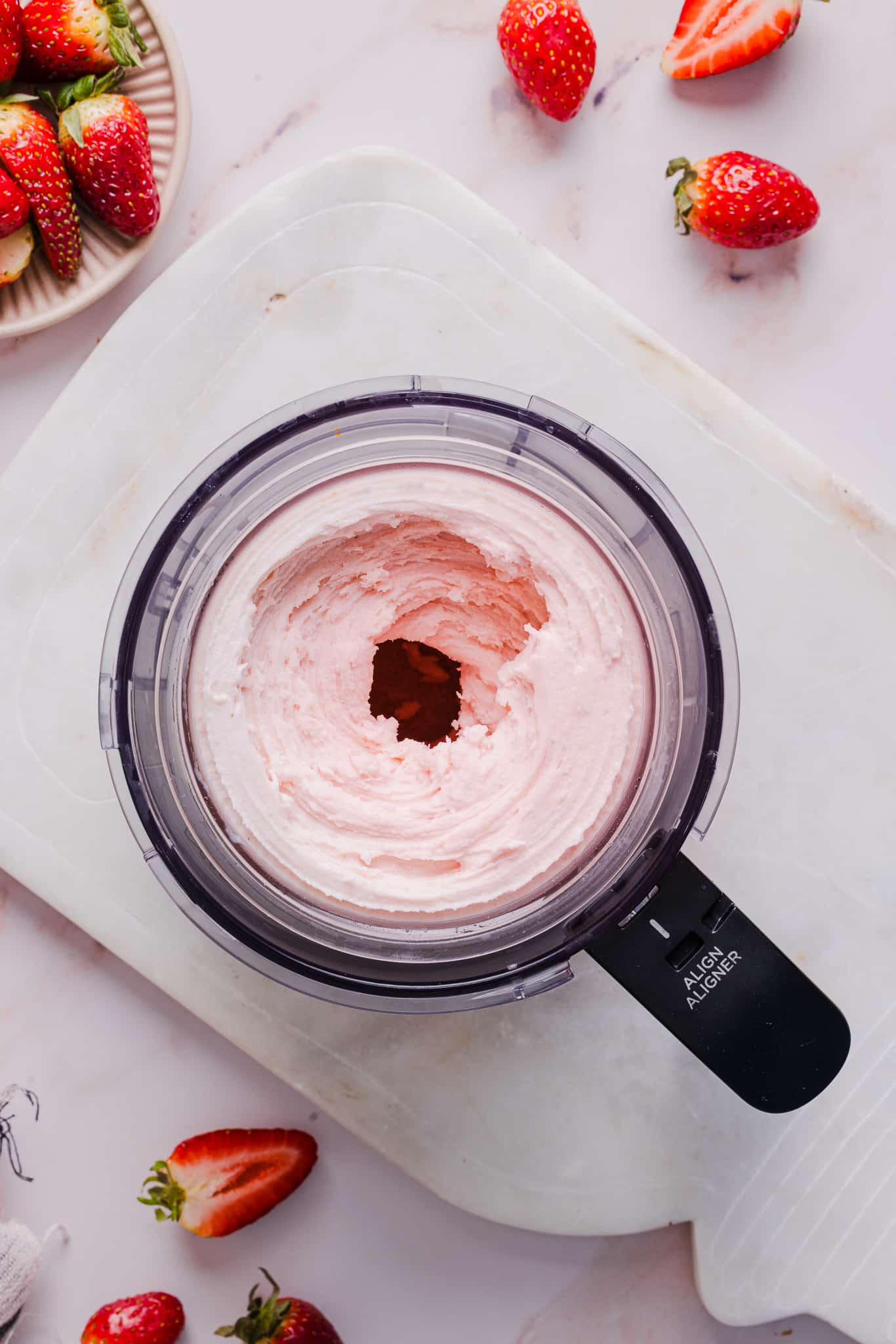 Strawberry ice cream in a Ninja Creami machine.